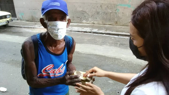 Persona sin hogar recibiendo comida en las calles